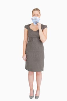Woman hiding her mouse with euro banknotes against white background