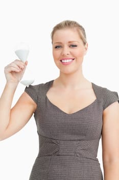 Woman smiling showing a hourglass in her hand against white background
