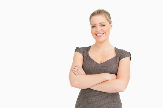 Woman standing with her arms crossed against white background