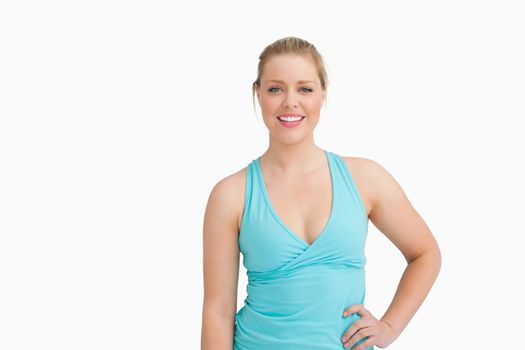 Woman with a blue t-shirt with a hand on her hip against white background