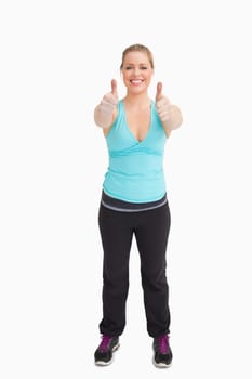 Woman wearing sportswear with thumbs up against white background