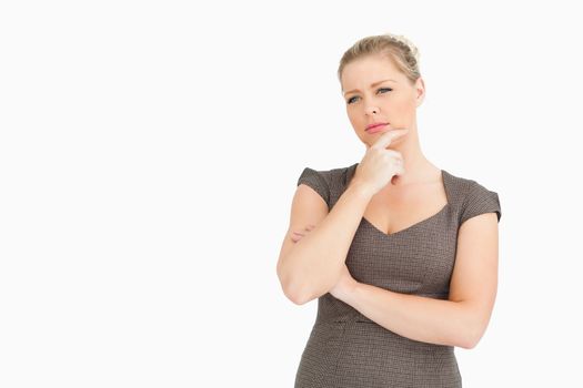 Woman standing while thinking about something against white background