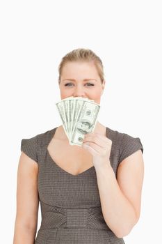 Pretty woman hiding her mouse with dollars banknotes against a white background