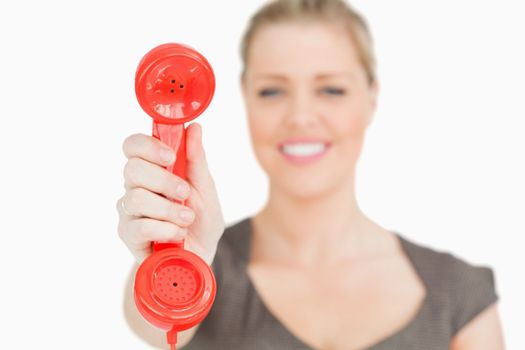 Retro red phone n a hand of woman against white background
