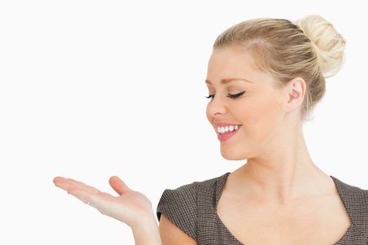 Woman looking at her hand against white background