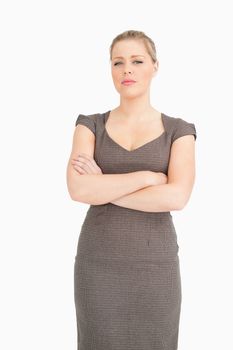 Serious woman standing with arms crossed against white background