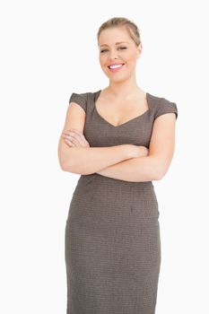 Woman standing with arms crossed against white background