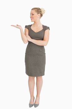 Woman looking her hand presenting something against white background