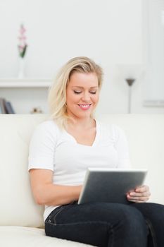Casual woman touching a screen of an ebook on a living room