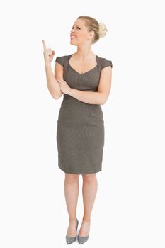 Woman showing something with her finger against white background