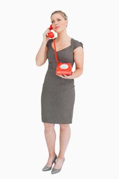 Woman calling someone with a retro phone against white background