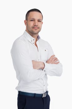Man standing and crossing his arms against a white background