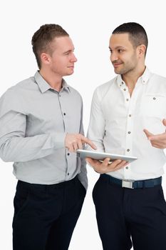 Two men together while holding a tablet computer against a white background