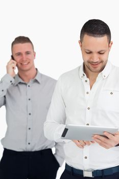 men using phone and tablet computer against a white background