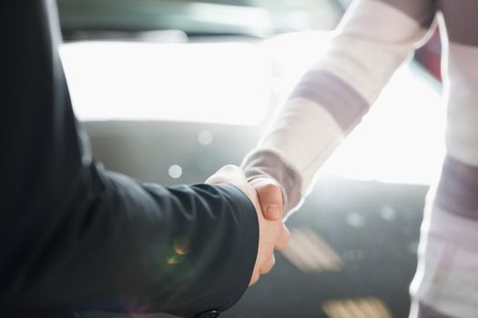 Two people shaking hands in a sunny place