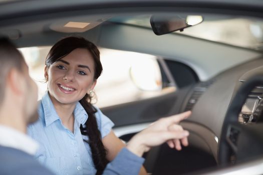 Man pointing a car interior while sitting in a car