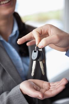 Woman smiling while receiving keys in a car shop