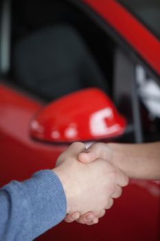 Hand shake in a car shop