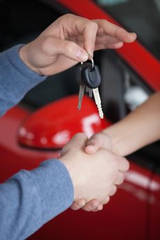 Hands shaking and keys being hold in a car shop