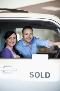 Couple in a sold car while smiling