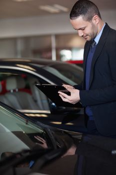 Salesman writing on a clipboard in a garage