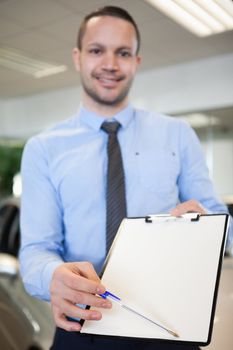 Salesman holding a contract in a dealership