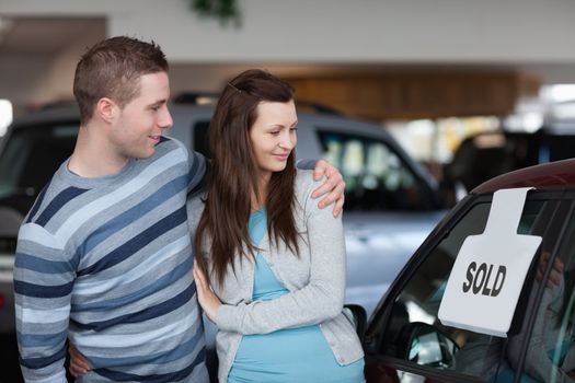 Couple looking to a new car in a dealership