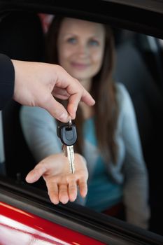 Dealer holding car keys by his fingertips in a dealership