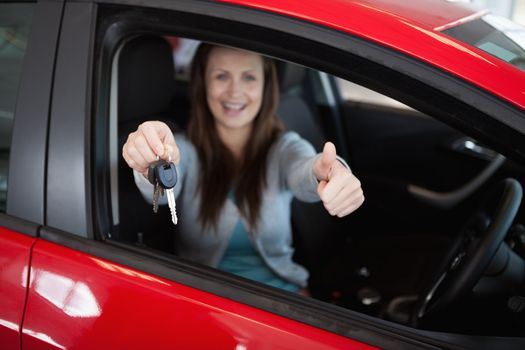 Woman sitting in her car while holding car keys