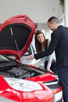 Dealer showing the car engine in a garage