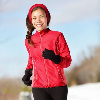 Fitness running woman. Closeup of female runner training and jogging outdoors in winter snow. Wellness workout and healthy lifestyle concept with mixed race Asian / Caucasian female fitness model.