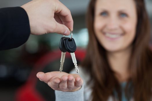 Woman smiling while receiving car keys in a garage