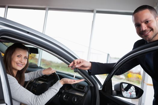 Woman sitting in her car while tending her hand in a garage