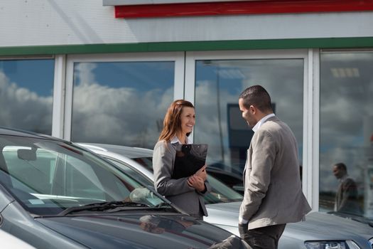 Businesswoman speaking  to a man in a garage