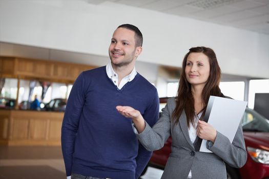 Woman showing something to a man in a dealership