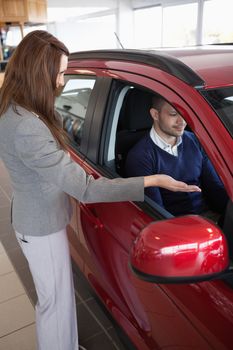 Woman presenting something to a client in a dealership