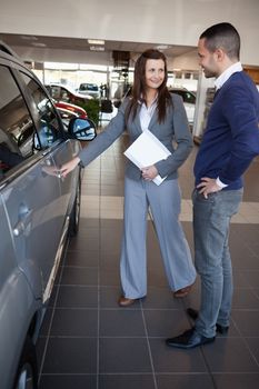 Woman holding car handle in a dealership