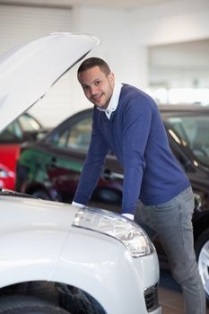Man leaning above a car in a garage