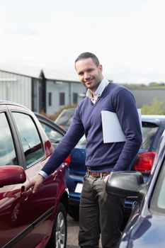 Man holding a car handle while holding a file outdoors