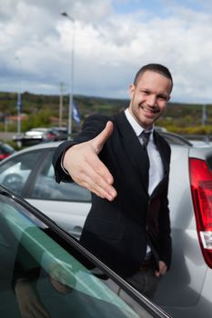 Businessman wanting to shake the hand of someone outdoors