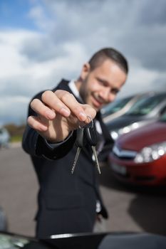 Happy businessman holding car keys outdoors