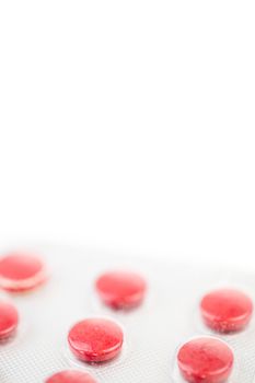 Close up of red medications against white background