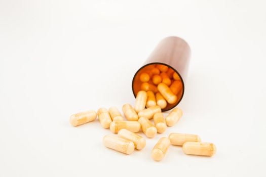 Bottle of medication knocked over against white background