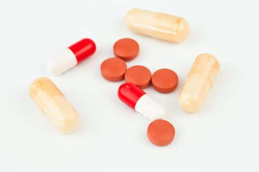 Pills dispersed against white background