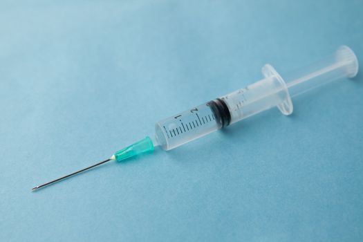 Surgical needle against a blue background