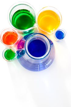 Six beakers and erlenmeyer against a white background