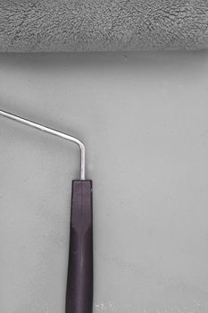 Grey paint roller with handle on a background