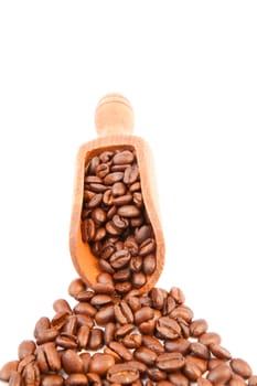 Wooden shovel filled of coffee beans against a white background