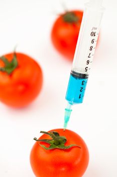 Syringe injecting blue liquid against a white abckground