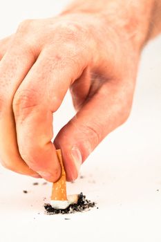 Hand extinguished a cigarette against a white background